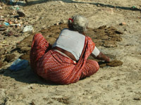 Woman making cowpat pies by the Ganges, Varanasi
