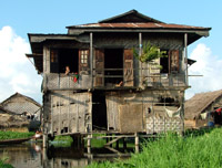 Children waving from a house on stilts, Lake Inle, Myanmar - formerly Burma